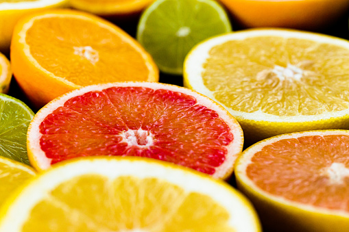 An overhead view of a collection of citrus fruit, including various types of grapefruit, oranges, limes and lemons.