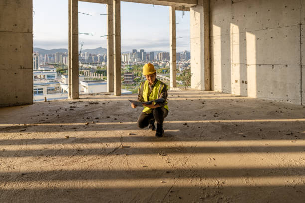 istock A female construction worker is holding blueprints and working on a construction site with sunlight 1476729849