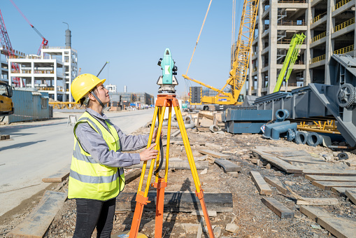 A beautiful female engineer was measuring on the construction site of a chemical factory