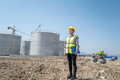 A female engineer works on the construction site of a chemical factory