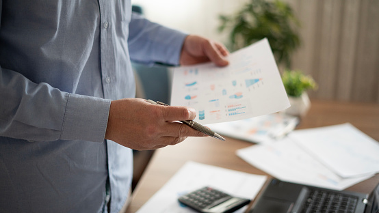 Adult businessman reviewing financial reports at home