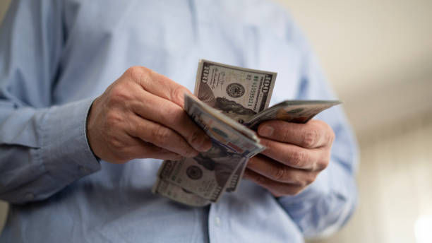istock Adult man counting dollars at home 1476731494