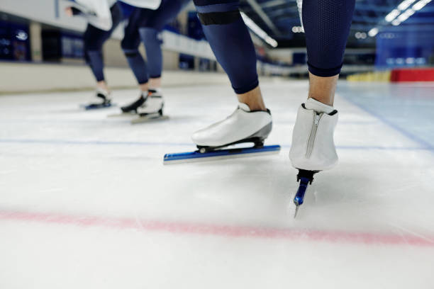 nahaufnahme des unteren teils der beine eines jungen sportlers in schlittschuhen - kurzstrecken eisschnelllauf stock-fotos und bilder