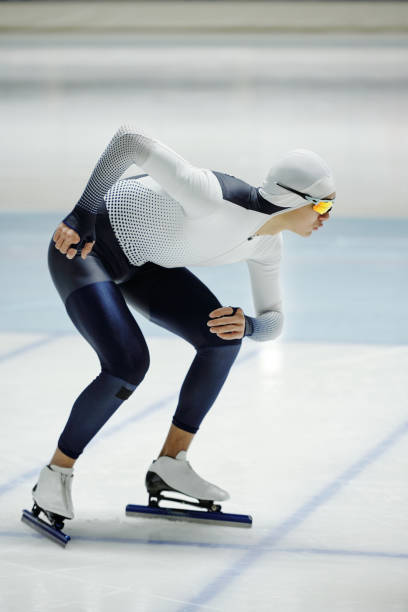 istock Active young man in speed skating uniform sliding forwards on ice 1476731838