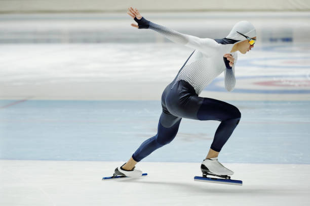 istock Side view of young active man in sports uniform practicing exercises on ice rink 1476731876