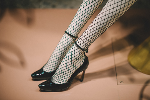 A low section view of a womans leg wearing stylish high heels footwear.