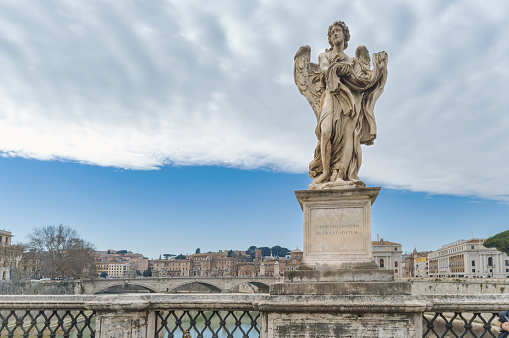 Bernini's Angelo statue of robes and dice on the Sant Angelo bridge in Rome Italy