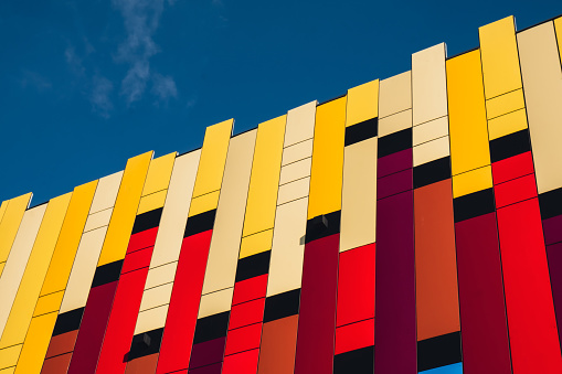 Modern colorful office building exterior with glass facade on clear sky background. Transparent glass wall of office building. Element of facade of modern European building Commercial office buildings. Abstract modern business architecture