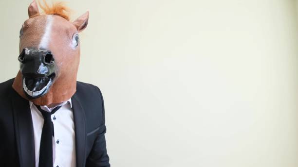 istock Funny horse head man pointing finger away on studio background. 1476741829