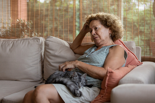 Argentinean 74 years-old woman going through a mental health problem. She is distressed and sad alone at home with her cat's company- Buenos Aires - Argentina