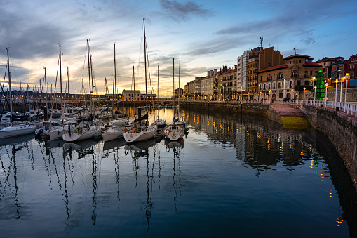Marina at sunset with promenade and sailing boats in the tourist city of Gijon, Asturias