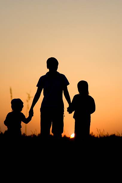 istock silhouette of mater and daughters in sunset 147674463