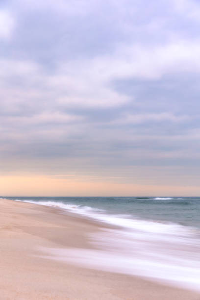 istock Soft silky waves receding back to the ocean on a peaceful beac 1476747522