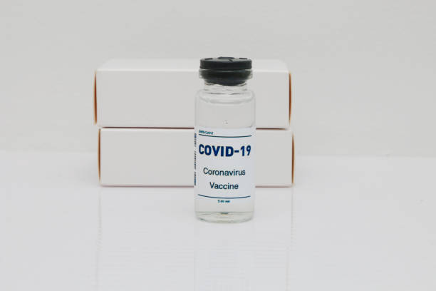 istock Ampoule with a vaccine and white small boxes on a white background. 1476747547