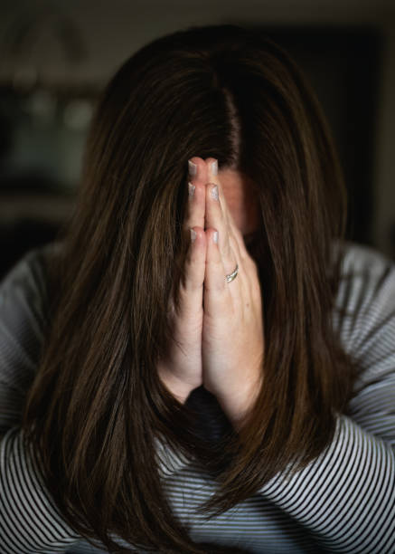 istock Young woman praying in home alone 1476750570