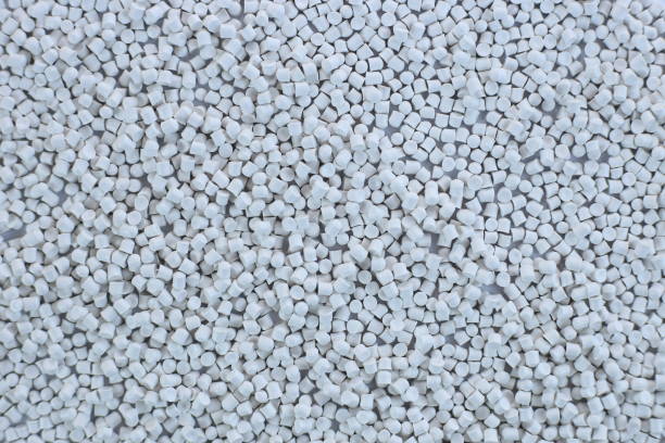 Close-up of white plastic polymer granules. polymer plastic. compound polymer. PVC resin compounds. Tinted plastic granulate for injection moulding process.