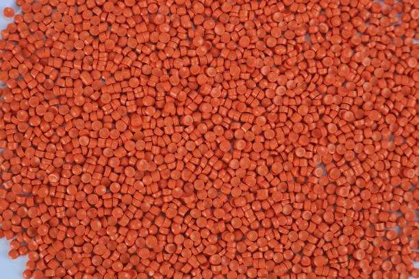 istock Close-up of orange plastic polymer granules. polymer plastic. compound polymer. PVC resin compounds. Tinted plastic granulate for injection moulding process. 1476751988