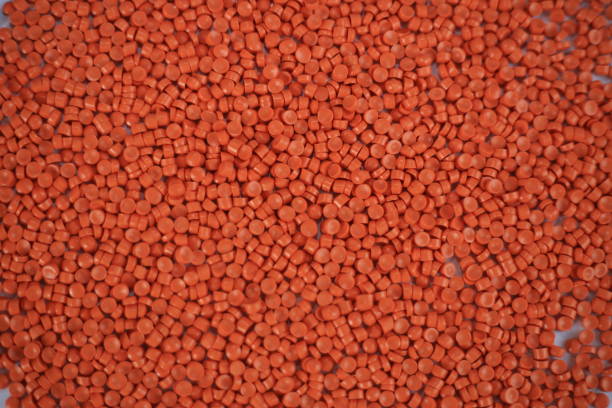 istock Close-up of orange plastic polymer granules. polymer plastic. compound polymer. PVC resin compounds. Tinted plastic granulate for injection moulding process. 1476752027
