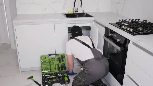 istock Water is flowing under the sink in the kitchen. Plumber in special clothes at work 1476753932