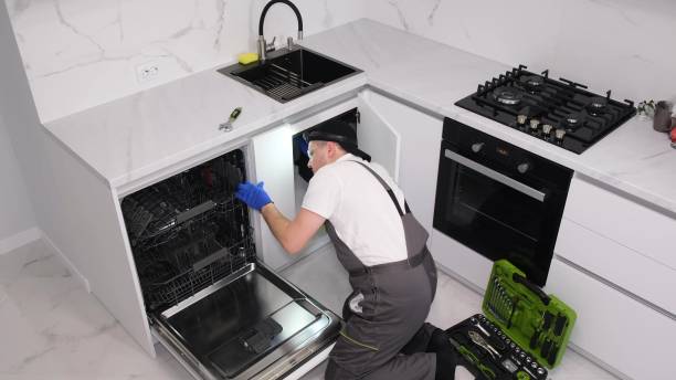 istock A plumber repairs a dishwasher in a kitchen room. Plumbing services 1476753944