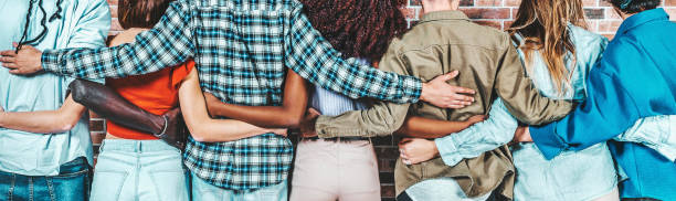 Back view of group of diverse people hugging each other - Support, help and youth community concept stock photo