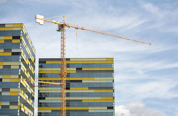 glass building glass building with yellow crane construction skyscraper machine industry stock pictures, royalty-free photos & images