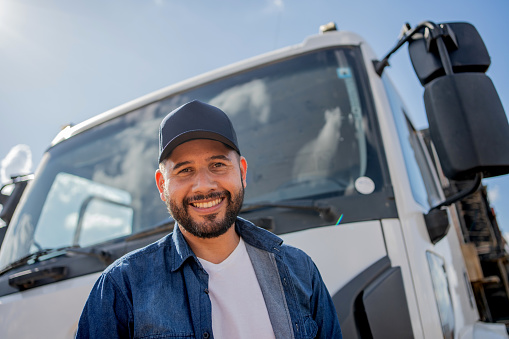 Portrait of truck driver in front of his truck