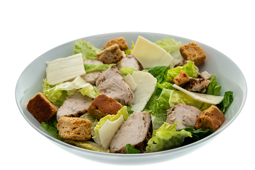 Caesar salad with parmesan cheese, grilled chicken meat and croutons - white background