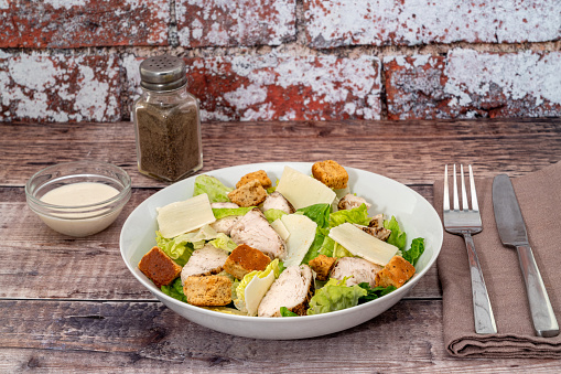 Caesar salad with parmesan cheese, grilled chicken meat and croutons