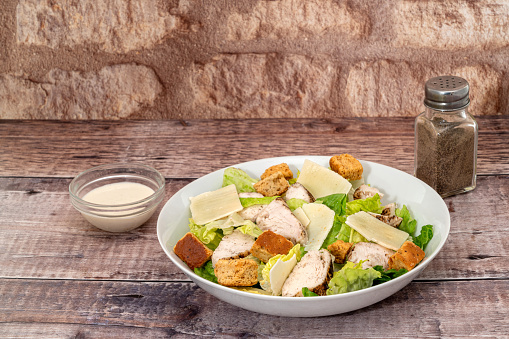 Caesar salad with parmesan cheese, grilled chicken meat and croutons