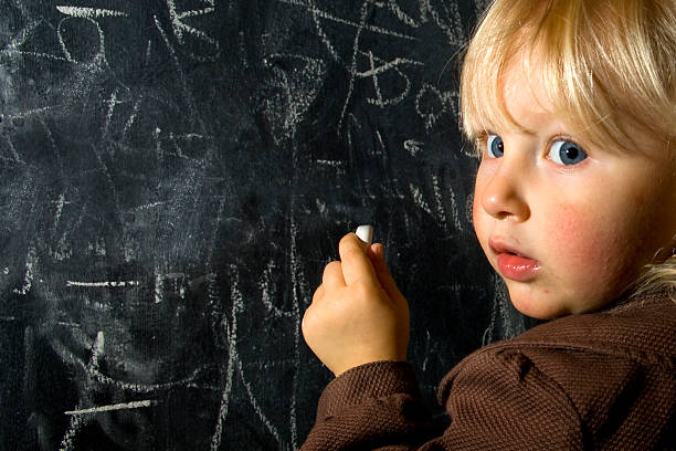 istock Little Blonde Girl at Chalkboard / Blackboard 147676013