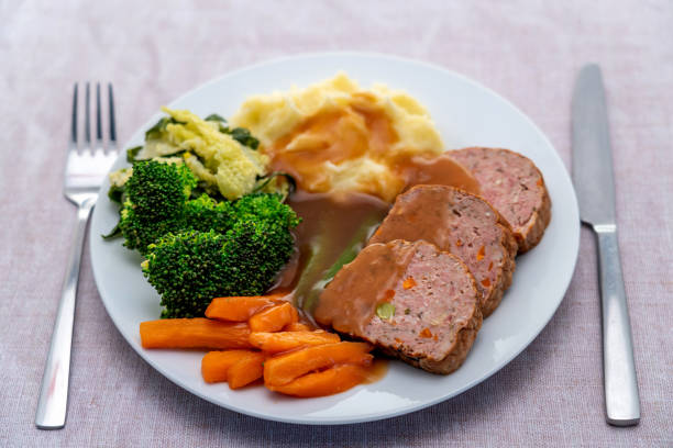 A meatloaf dinner with vegetables and gravy