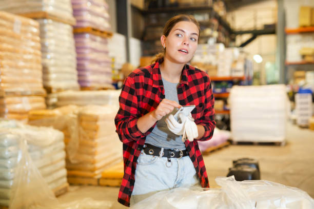 istock Woman checking availability on smartphones in storage warehouse 1476761732