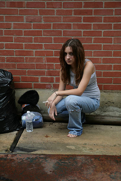 homeless girl smoking on a city street