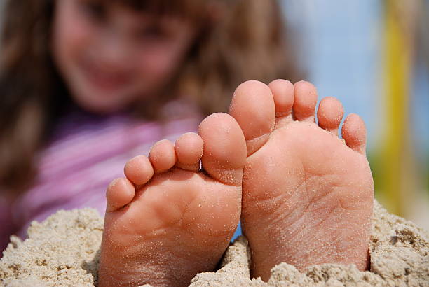 istock Girl's feet in the sand 147676229