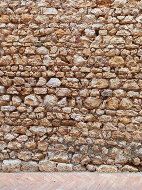 Old wall of stone and mud. Rustic stone facade. Constructions and Architecture.