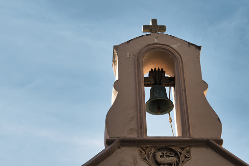 Bonifacio, France - March 15, 2023. View of a church tower located in the citadel with its cast iron bell.