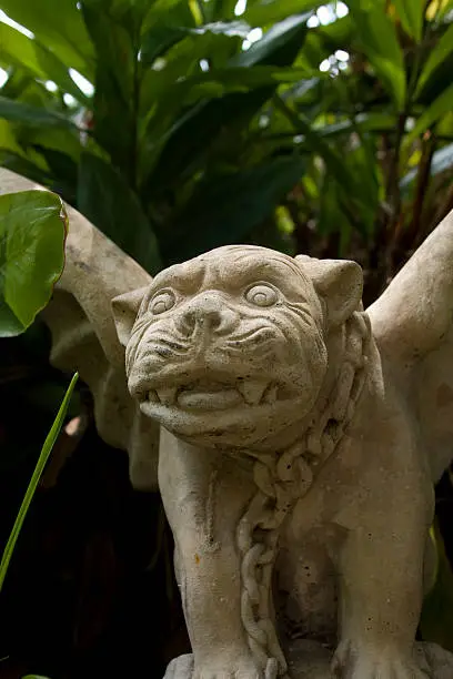 angry gargoyle peering out of the bushes