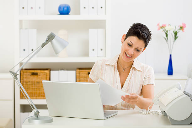 istock Woman sitting at desk reading business document 147677327
