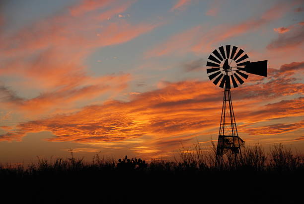A windmill at dusk with clouds in the sky