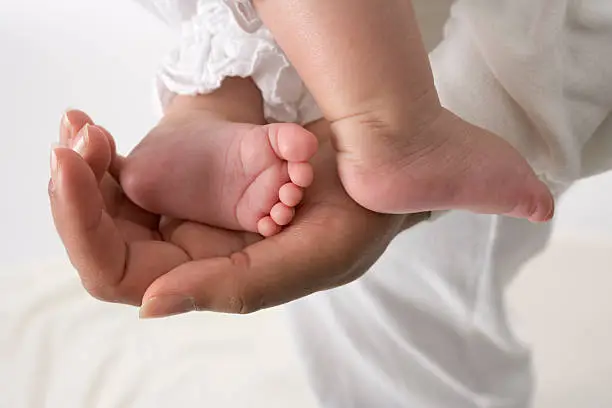 Mothers hand is showing little babyfeet