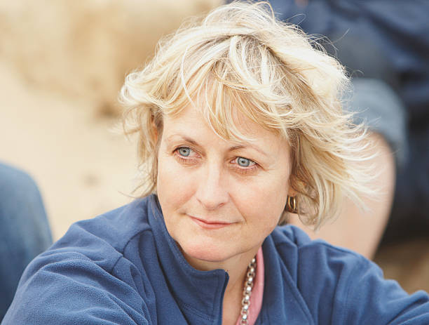 A happy mature woman relaxing on terrace in summer.