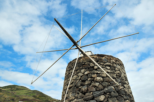 Vila do Corvo, Corvo Island, Azores, Portugal: Traditional stone windmill, covered in conical rooftop that rotates, made of wood, from which springs the main shaft and sail axis - southern tip of Corvo Island, opposite the airfield on the small inclined area known as Ponta Negra.