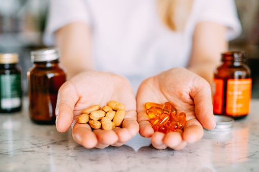 Woman Holding Vitamin Pills in Her Palms