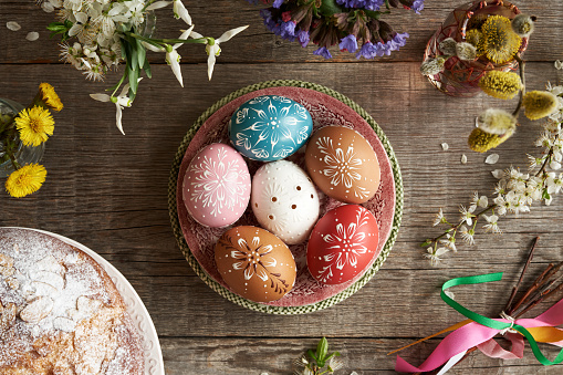 Easter eggs decorated with wax ornaments with spring flowers and mazanec - traditional Czech sweet Easter pastry