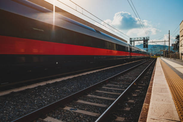 istock Long train arrives at rural train station in Italy. 1476783791