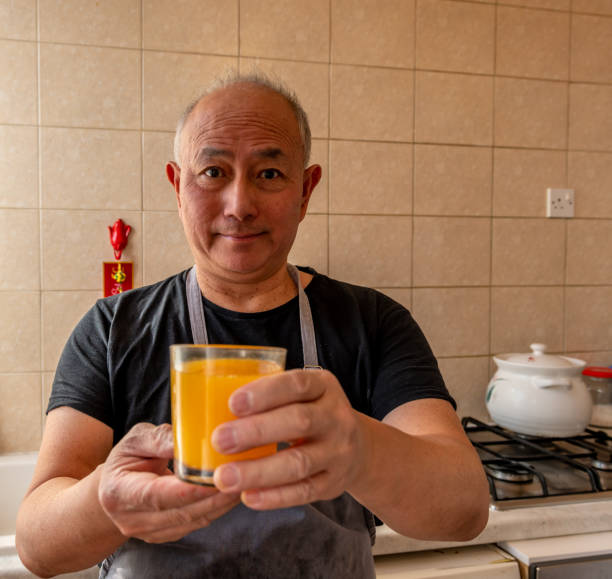 istock A elderly cook presenting a glass of freshly squeezed orange juice. 1476784248