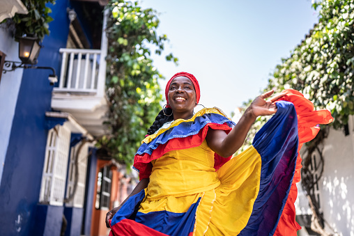 Palenquera walking and dancing on the street in Cartagena, Colombia