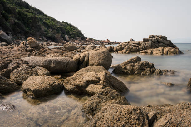 langzeitbelichtung von felsen und meer an der küste der insel sardinien, italien - long exposure rock cloud sky stock-fotos und bilder