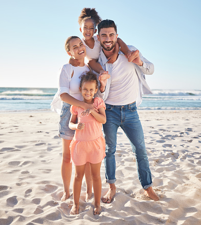 Family, portrait and happy smile on the beach with children and parents on sand in the sun. Summer fun of kids, mother and man by the ocean water and waves with happiness and quality time in nature